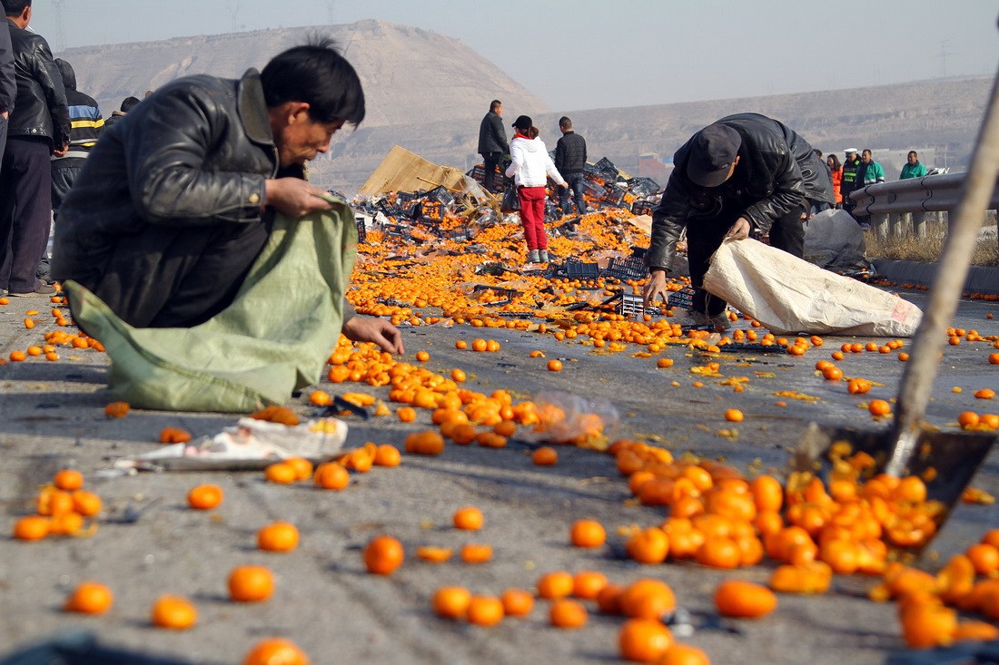 组图:警察拔枪制止哄抢橘子引争议 维持秩序可